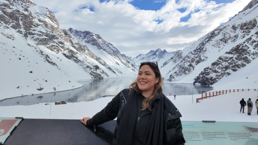 Mulher em Portillo no Chile com a cordilheira e a Laguna del Inca ao fundo